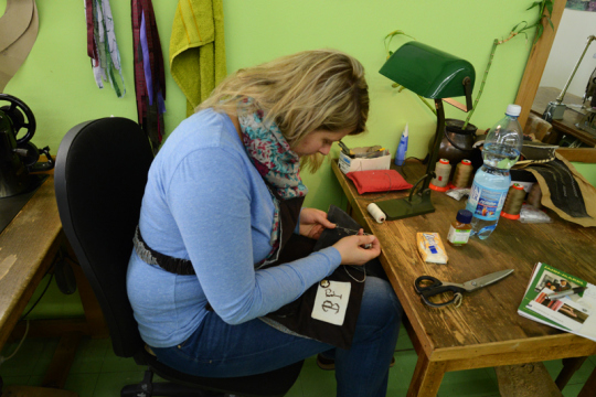 Die Säcklerin Bernadette beim Besticken einer Lederhose.